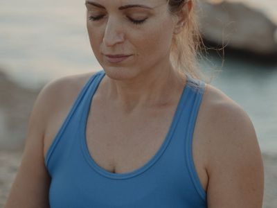 Person doing a balance exercise against a dark wall